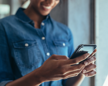 A woman holds a phone in her hands.