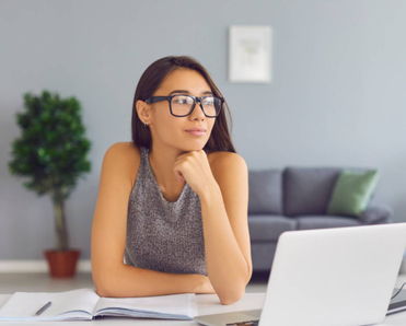 Woman thinking while sitting at her computer desk.