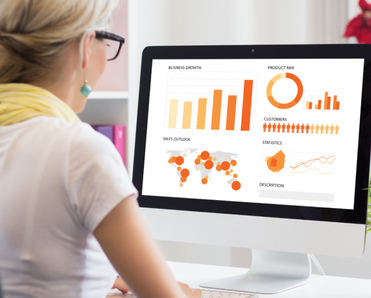 Woman looks at charts and graphs on a mac.