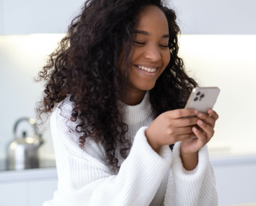 Woman uses a smartphone in her kitchen.