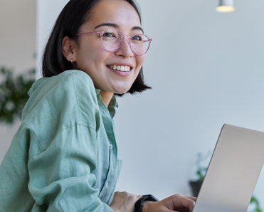 Woman smiles while on laptop. 