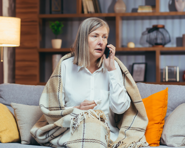 An older woman is talking on the phone. 