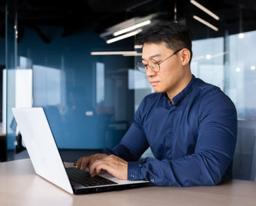 Man types on his computer in an office.