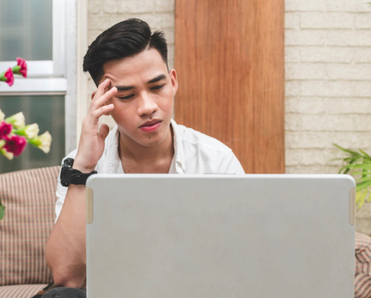 Man looking frustrated at laptop