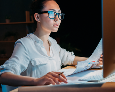 A woman uses her computer at night.