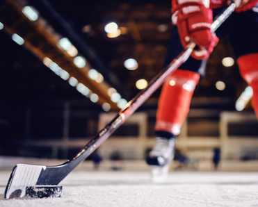 Close up of hockey player skating with stick and puck.