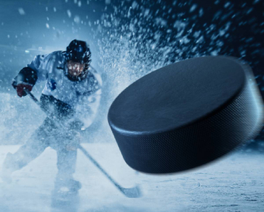A close up of a hockey puck hurling toward the fore