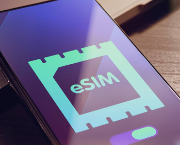 eSIM - Embedded SIM technology concept with smartphone very close lying on a wooden table with esim icon on the screen