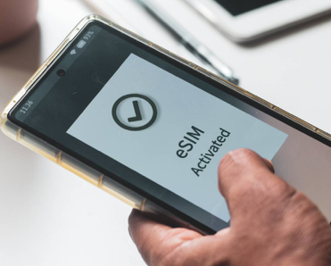 A person&#x27;s mobile phone displaying &quot;eSIM activated&quot;