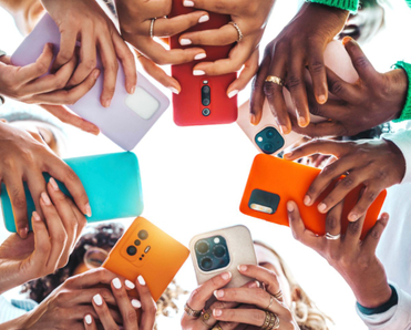 Teens holding cell phones in a circle