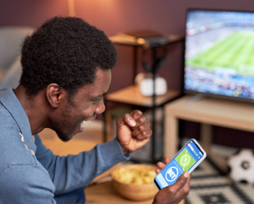A man cheering while placing NFL bets