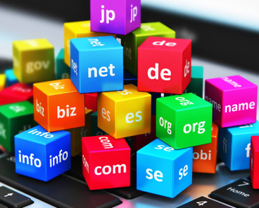 domain name concept of TLDs stacked as colored blocks atop a laptop keyboard