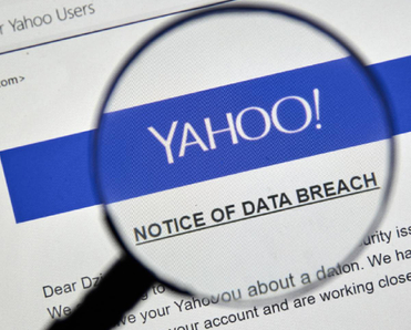 Closeup of a magnifying glass displaying a Yahoo data breach notice