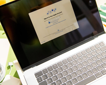 MacBook Air M4 is shown during initial setup process with Apple ID login screen visible.