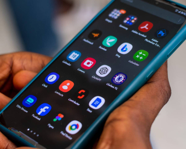 Close-up of a pair hands holding their Android phone looking at a screen of apps