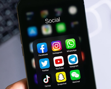 Phone screen open to a social media folder with familiar apps like Facebook and Instagram.