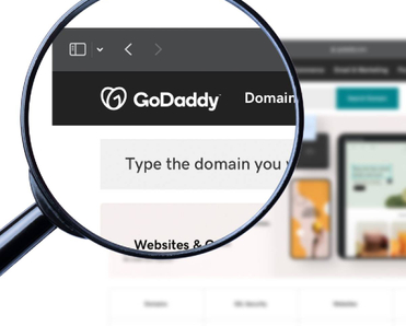 GoDaddy logo on the homepage under a magnifying glass