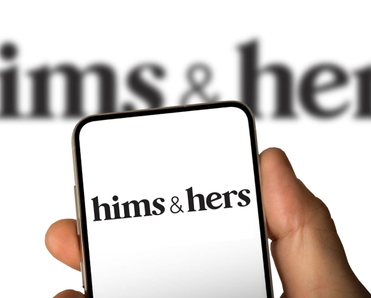 Phone screen with Hims &amp; Hers logo in front of a blurry screen.