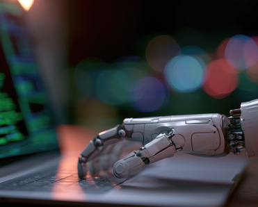 Robotic hand typing on laptop displaying code.