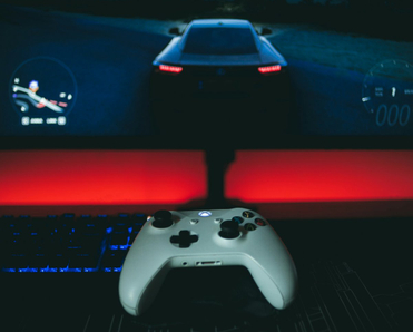 A video game controller sitting in front of a monitor