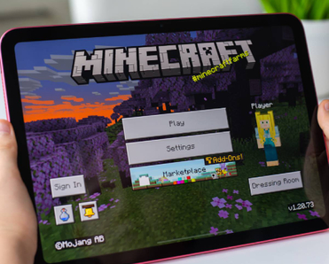 Child holding iPad with Minecraft on screen