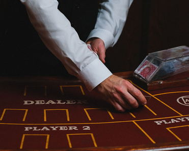 A blackjack table dealer dealing.