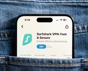 Closeup of back jeans pocket featuring smartphone with Surfshark app market on screen