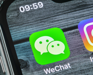 Wechat messenger application icon on Apple iPhone X smartphone screen close-up. 