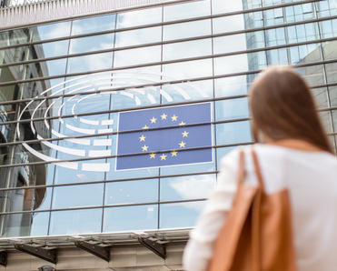 Young businesswoman standing back near the Parliament building of European Union in Brussel city.