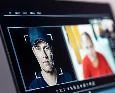 Computer analyzing a man's face and matching it to other photographs of him.