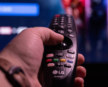 closeup of hand holding an LG smart TV remote