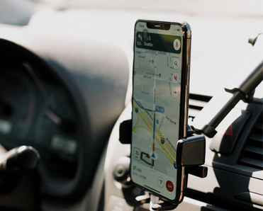 A phone open to Google Maps mounted in a car.