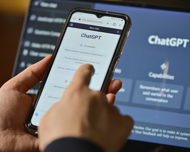 Person using ChatGPT on mobile and laptop