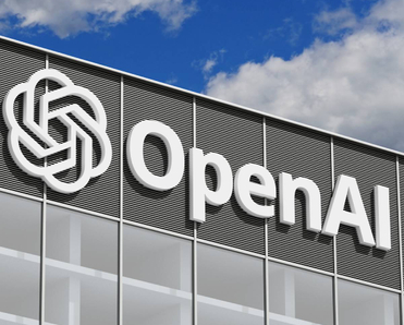 OpenAI logo on a gray corporate building against a blue sky