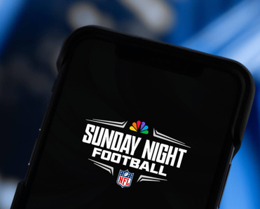A closeup of a smartphone displaying Sunday Night Football and NBC and NFL emblems