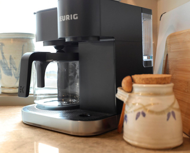 Closeup shot of a coffee station with a Keurig coffee machine in a kitchen.