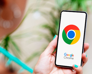 Woman with blue nails holding smartphone displaying Google Chrome logo