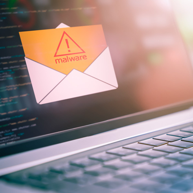 A close-up photo of a laptop with an open envelope icon and a yellow document that says malware coming out of it