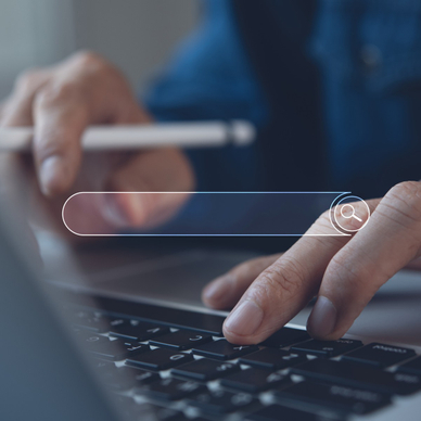 A close-up of a man&#x27;s fingers typing on a Mac laptop keyboard with an illustration of a web browser search bar