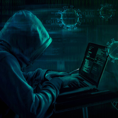 A hooded hacker on their laptop, sending out an online pandemic scam.