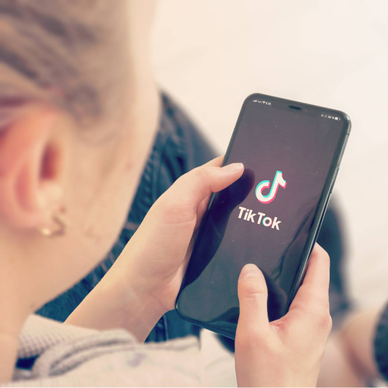 A young girl opening TikTok on her smartphone.