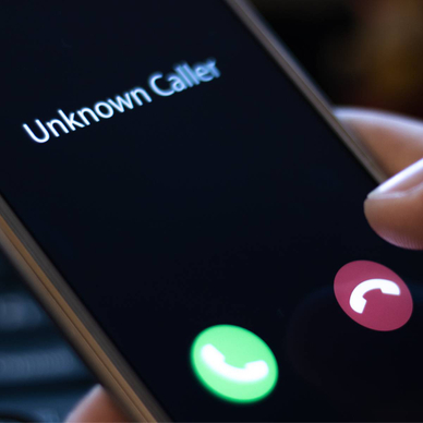 A close-up of a smartphone screen receiving a call from an unknown caller.