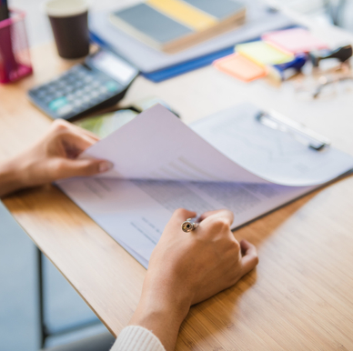 A woman signs mortgage paperwork and will receive a home title that proves she owns her home.