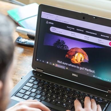 A man on his laptop is visiting the Airbnb website.
