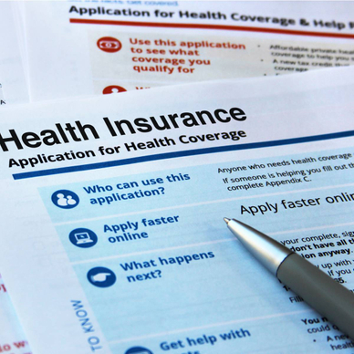 A health insurance application and a pen.