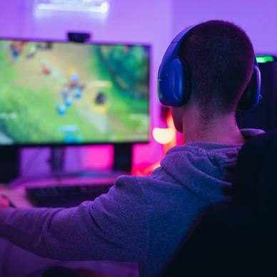 A young gamer playing online video games while streaming on social media.