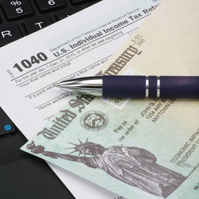 U.S. IRS income tax filing form 1040 with a pen on a keyboard.