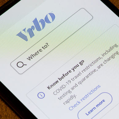 Phone screen with Vrbo rental app for vacation 