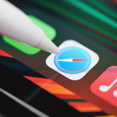 An Apple Pencil points at the Safari web browser icon on an iPad.