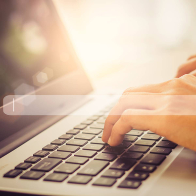 A pair of hands typing on a laptop with an abstract search bar in the foreground.